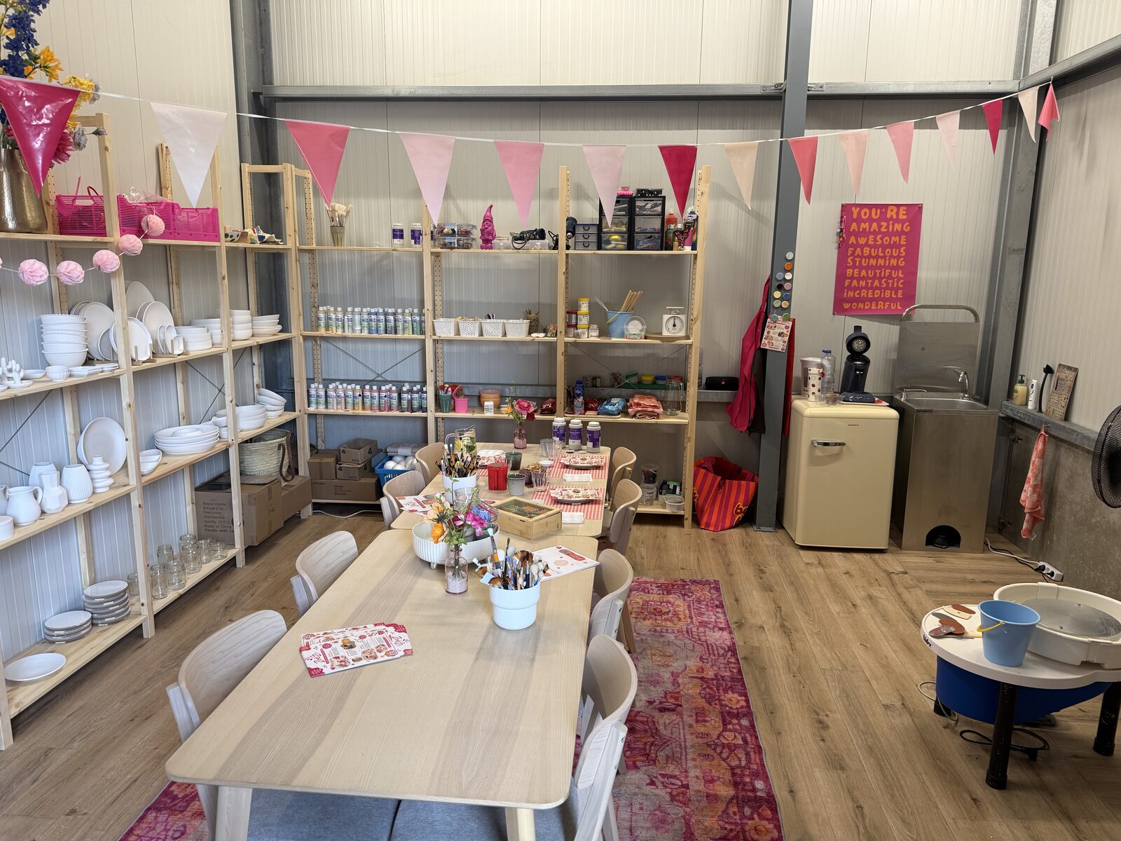 Het atelier van ZoëZo Creatief feestelijk ingericht met slingers, gedekte tafels en kasten vol materialen