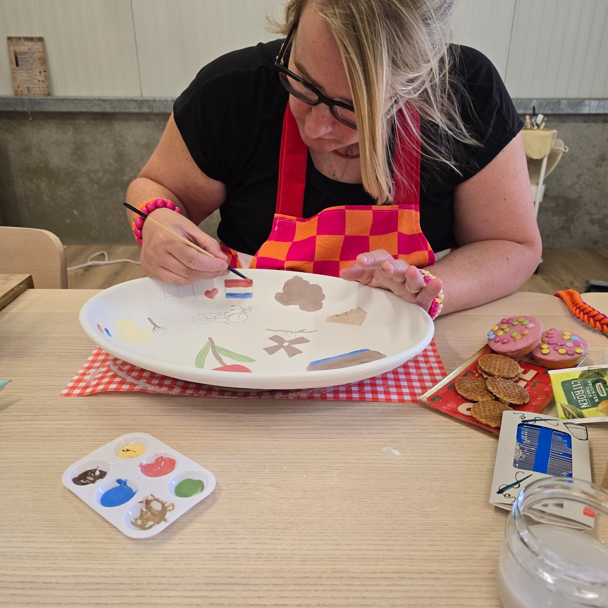 Deelneemster beschildert keramiek tijdens een creatief vrijgezellenfeest bij ZoëZo Creatief